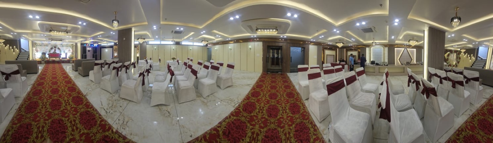 Panoramic view of the fully set banquet hall at Hotel Veda Inn